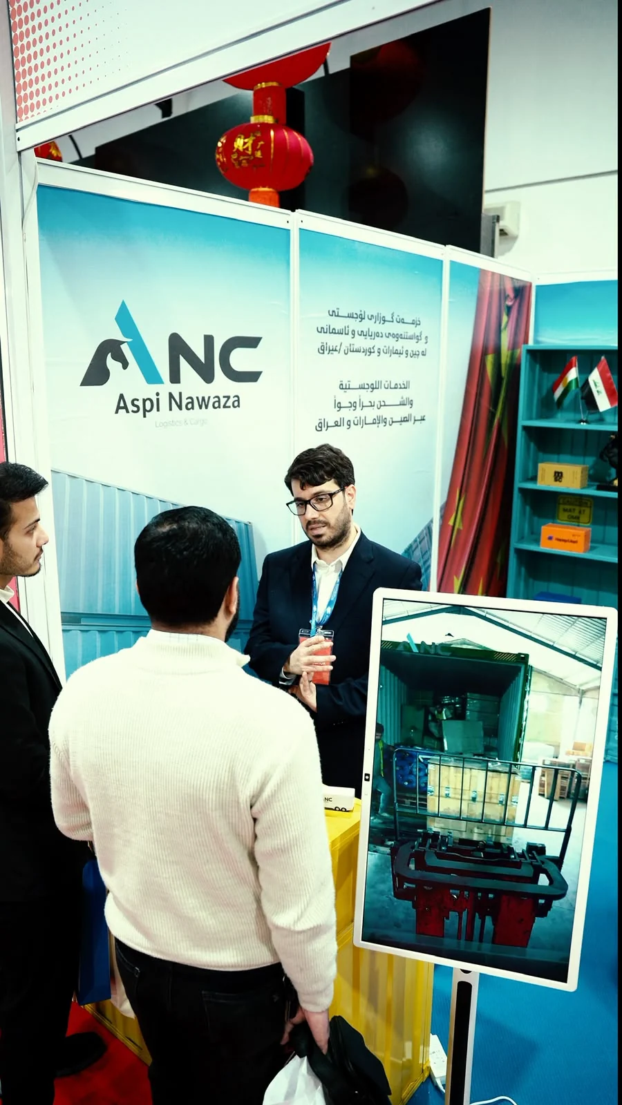ANC 团队成员在展示仓库运营状况的屏幕旁向访客讲解