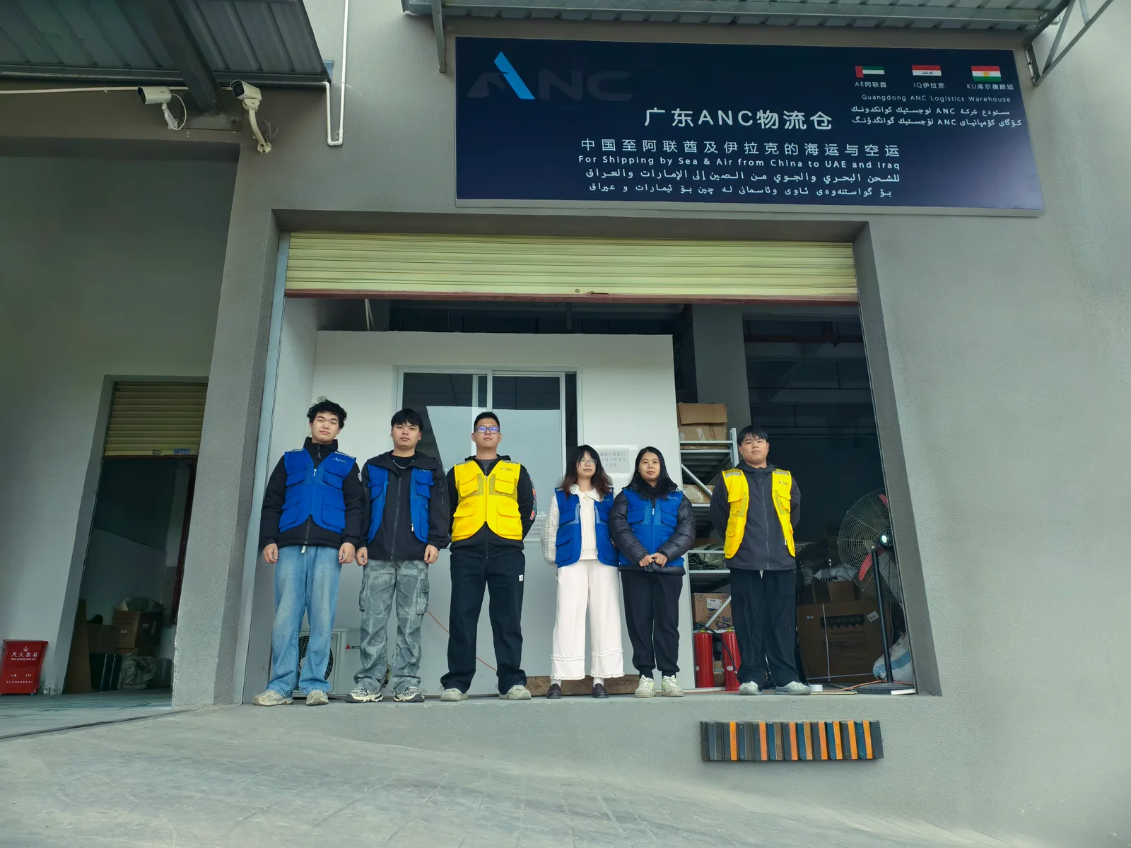 ANC 团队在佛山设施外招牌下合影